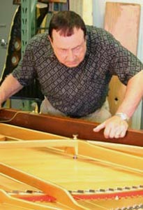 Giovanni Skilan restringing a grand piano