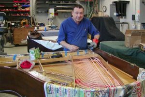Giovanni restringing one of the hundreds of pianos throughout his life