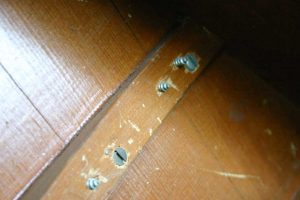 Oversized screws and other sloppy work on bad piano repair