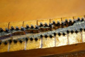 Closeup of piano bridge with termite damage