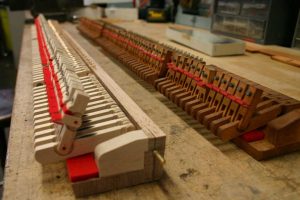 Old vs. new Steinway damper tray replacements by Renner